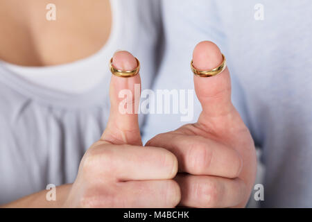 In der Nähe von ein paar Mit Hochzeit Gold Ringe in ihre Daumen Stockfoto