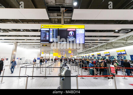 England, Heathrow Terminal 4. Leute anstellen an der Internationale Abflüge Schreibtische in der Kontrolle der mit Gepäck. Interieur. Nacht. Stockfoto