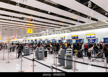 England, Heathrow Terminal 4. Leute anstellen an der Internationale Abflüge Schreibtische in der Kontrolle der mit Gepäck. Interieur. Nacht. Stockfoto