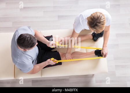 Ansicht eines weiblichen Physiotherapeuten geben Übung Behandlung für Mensch Stockfoto