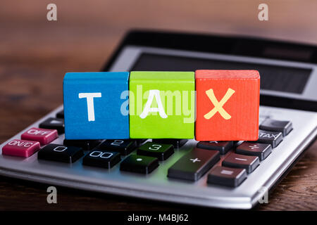 In der Nähe der bunten Bausteine mit Word Steuern über Taschenrechner Stockfoto