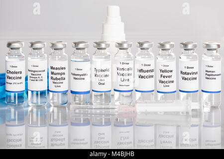 Spritze und Impfstoff Flaschen mit verschiedenen Etiketten in einer Reihe Stockfoto