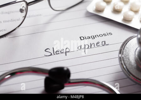 Diagnose Schlafapnoe auf weißem Papier mit Drogen und Stethoskop im Hintergrund Stockfoto