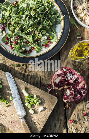 Grüner Salat mit Granatapfel, manna Kruppe, Zwiebel Stockfoto