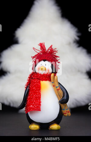 Pinguin Figur mit weißer Weihnachtsbaum auf Schwarz Stockfoto