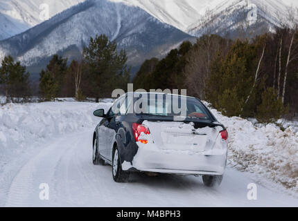 Auto fährt auf der verschneiten Straße in Transbaikalien Nationalpark. Stockfoto