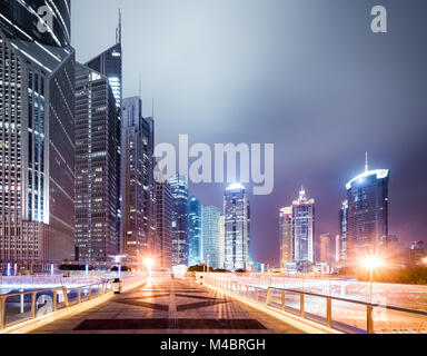 Fußgängerbrücke und moderne Gebäude bei Nacht Stockfoto