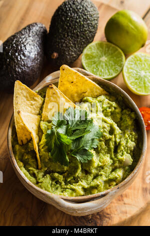 Tortilla Chips in Schale guacamole mit Avocado und Limetten Stockfoto