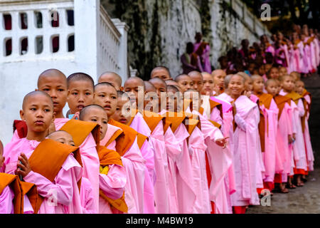 Buddhistische Nonnen in Warteschlange stehen in einer langen Reihe Spenden in ein Kloster zu erhalten Stockfoto