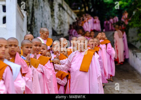 Buddhistische Nonnen in Warteschlange stehen in einer langen Reihe Spenden in ein Kloster zu erhalten Stockfoto