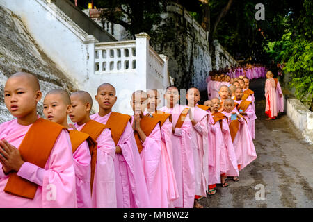 Buddhistische Nonnen in Warteschlange stehen in einer langen Reihe Spenden in ein Kloster zu erhalten Stockfoto