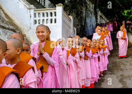 Buddhistische Nonnen in Warteschlange stehen in einer langen Reihe Spenden in ein Kloster zu erhalten Stockfoto