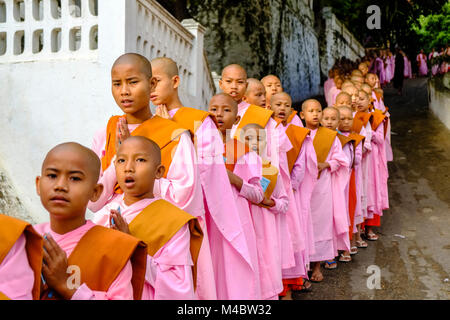 Buddhistische Nonnen in Warteschlange stehen in einer langen Reihe Spenden in ein Kloster zu erhalten Stockfoto