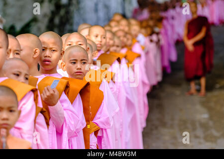 Buddhistische Nonnen in Warteschlange stehen in einer langen Reihe Spenden in ein Kloster zu erhalten Stockfoto