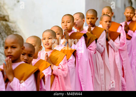 Buddhistische Nonnen in Warteschlange stehen in einer langen Reihe Spenden in ein Kloster zu erhalten Stockfoto