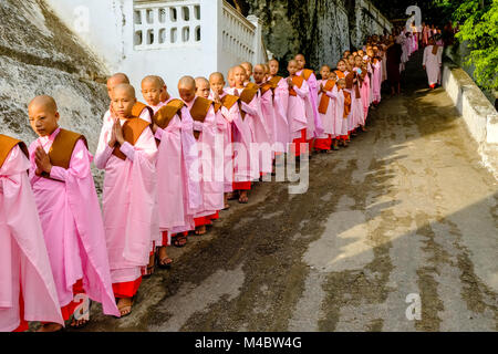 Buddhistische Nonnen in Warteschlange stehen in einer langen Reihe Spenden in ein Kloster zu erhalten Stockfoto