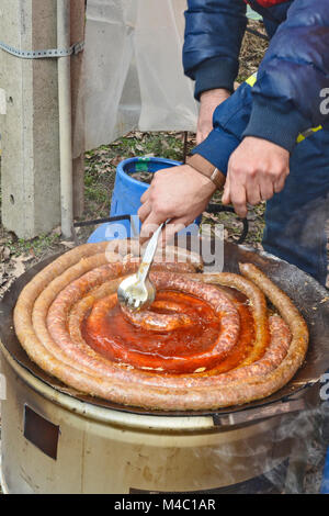 Zwei Männer traditionell zubereitete Wurst draußen auf der Straße zu verkaufen. Stockfoto