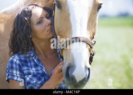 Frau und Pferd zusammen im Fahrerlager Stockfoto