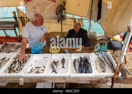 ZAKYNTHOS, Griechenland - 29. September 2017: Ein Mann verkauft frische Fische an der Strandpromenade. Insel Zakynthos, Griechenland Stockfoto
