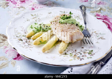 Kabeljaufilet mit weißem Spargel auf dem Teller Stockfoto