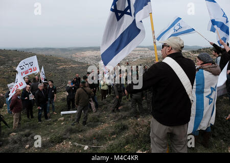 Jüdische Siedler und Aktivisten der rechten Organisation im Tirtzu halten israelische Flaggen, wenn sie israelischen linken Aktivisten der Peace Now-Bewegung gegenübertreten, die in Nativ Ha'avot offiziell gegen eine Ausweitung der jüdischen Siedlung Elazars im Siedlungskomplex Gush Etzion im Westjordanland demonstrieren. Am 15 Februar 2018. Die israelische Regierung versucht trotz des Urteils des Obersten Gerichtshofs, die Räumung einiger Häuser im Außenposten zu verschieben. Kredit: Eddie Gerald/Alamy Live News Stockfoto