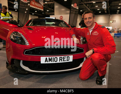 RAF Red Arrows Squadron Leader Adam Collins mit Aston Martin Red 10 - AMOC steht auf dem Car Club Square auf der London Classic Car Show 2018 Stockfoto