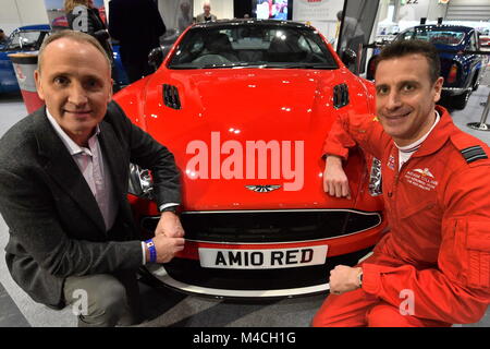 RAF Red Arrows Squadron Leader Adam Collins (rechts) mit dem Gewinnen Verlosung Ticketinhaber Humphrey Bradley, ein Aston Martin Rot 10, die für Nächstenliebe in der Vorschau der London Classic Car Show versteigert wurde, bei ExCeL im East London gewonnen. Stockfoto