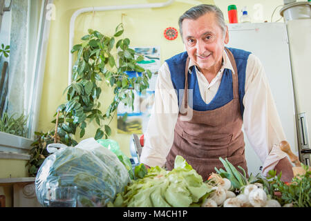 Älterer Mann mit Gemüse in der Küche Stockfoto