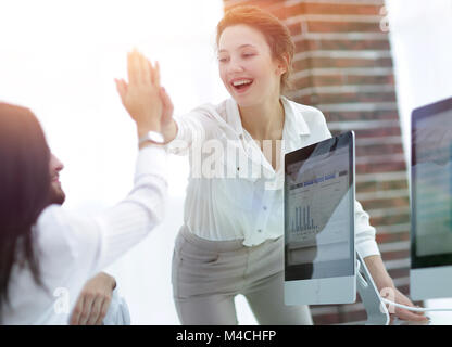 Freudige Kollegen zeigen Ihren Erfolg, indem Sie jedem anderen "fünf". Stockfoto