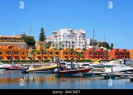 Yachten und Motorboote in der Marina mit Ferienwohnungen an der Rückseite, Portimao, Algarve, Portugal, Europa günstig. Stockfoto