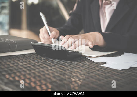 Frau berechnen inländischen Rechnungen zu Hause. Geschäftsfrau mit Rechner an moderne Büro. Junge weibliche Kontrolle Balance und Kosten. Start zählen fi Stockfoto