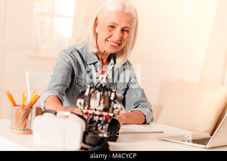 Ältere Techniker Prüfung neu konstruierten Roboter Stockfoto