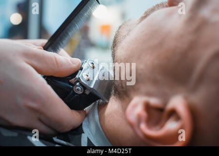 Friseur nivelliert sein Bart an den Clientcomputer für die Rasur. Der Client erhält die perfekte Form ihres Bartes. Soft Focus. Stockfoto