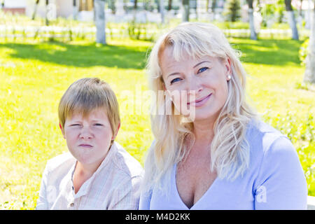 Blonde Frau und Sohn im Sommer lächelnd Stockfoto