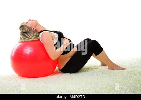 Schwangere Frau mit Gymnastikball Stockfoto