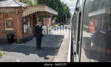 Die Station Master steht am Bahnsteig 2 in Toddington Bahnhof, der sich teilweise Gloucestershire und Warwickshire Steam Railway Heritage Line. England. UK. Stockfoto