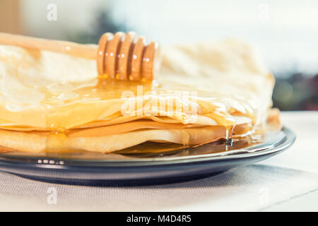 Honig ist auf einem Stapel Pfannkuchen gegossen Stockfoto