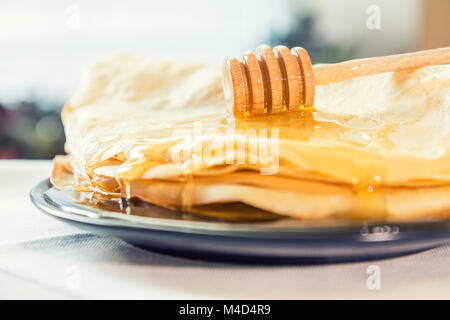 Honig ist auf einem Stapel Pfannkuchen gegossen Stockfoto