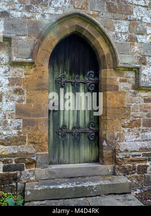 Eine gewölbte Tür an der Wand von St. Leonard's Kirche, Priors Marston, England, UK. Stockfoto