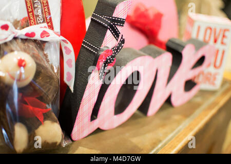 Ein rosa Liebe neben einem kleinen braunen Teddy mit Schleife gebunden. Stockfoto