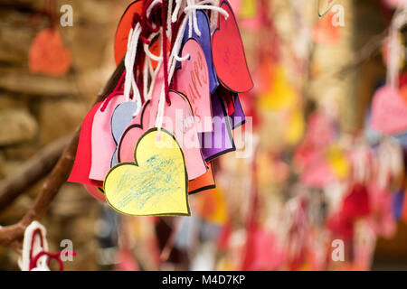 Papier Herzen durch Kinder Auflistung der Dinge, die Sie zu einem Baum mit weißen String Band lieben. Stockfoto