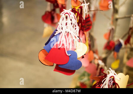 Papier Herzen durch Kinder Auflistung der Dinge, die Sie zu einem Baum mit weißen String Band lieben. Stockfoto