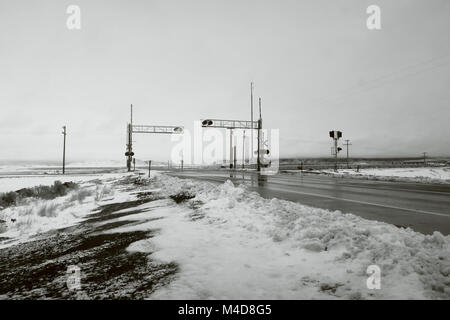 Ein bahnübergang im Winter in Schwarz und Weiß. Stockfoto