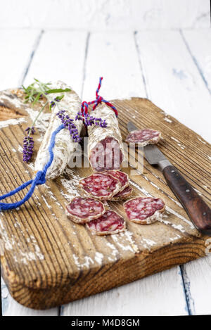 Salami in Scheiben geschnitten auf Schneidebrett Stockfoto