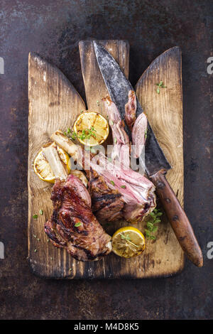 Grill Lamm Knuckles auf altem Schneidebrett Stockfoto