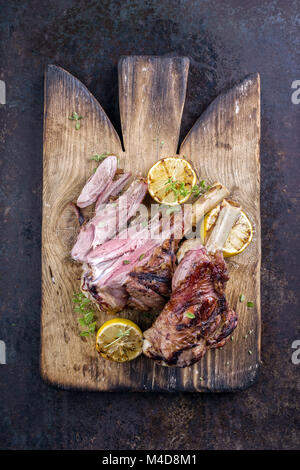 Grill Lamm Knuckles auf altem Schneidebrett Stockfoto