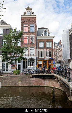 Reihenhäuser an der Ecke der Straße und Kanal im Zentrum von Amsterdam, Niederlande. Coffee House auf 1. Ebene. Stockfoto