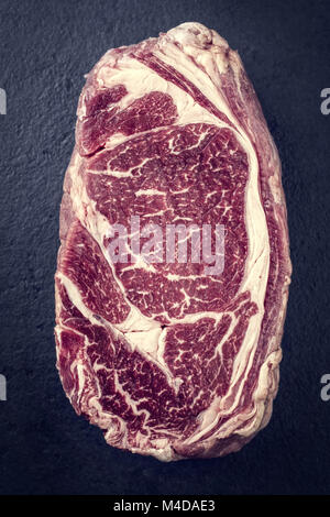 Raw trockenen Jahren Entrecote Steak als "Vintage" auf einer Schiefertafel Stockfoto