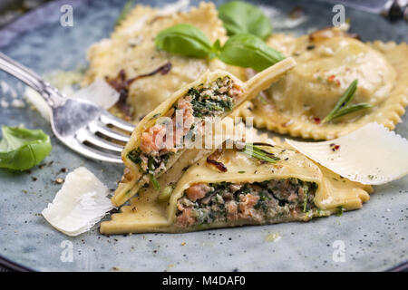 Gefüllte Nudeln mit Lachs auf einen schwarzen Stein Platte Stockfoto