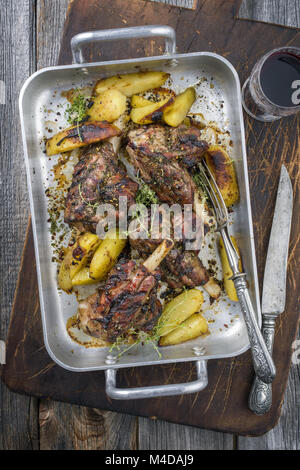 Grill Lamm Knuckles mit Bratkartoffeln in der Röstung Dish Stockfoto